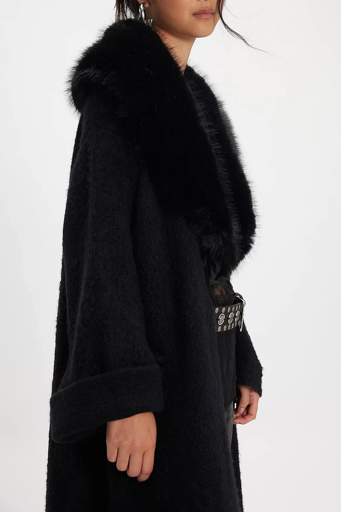 Black coat with fur collar worn by a person on a white background