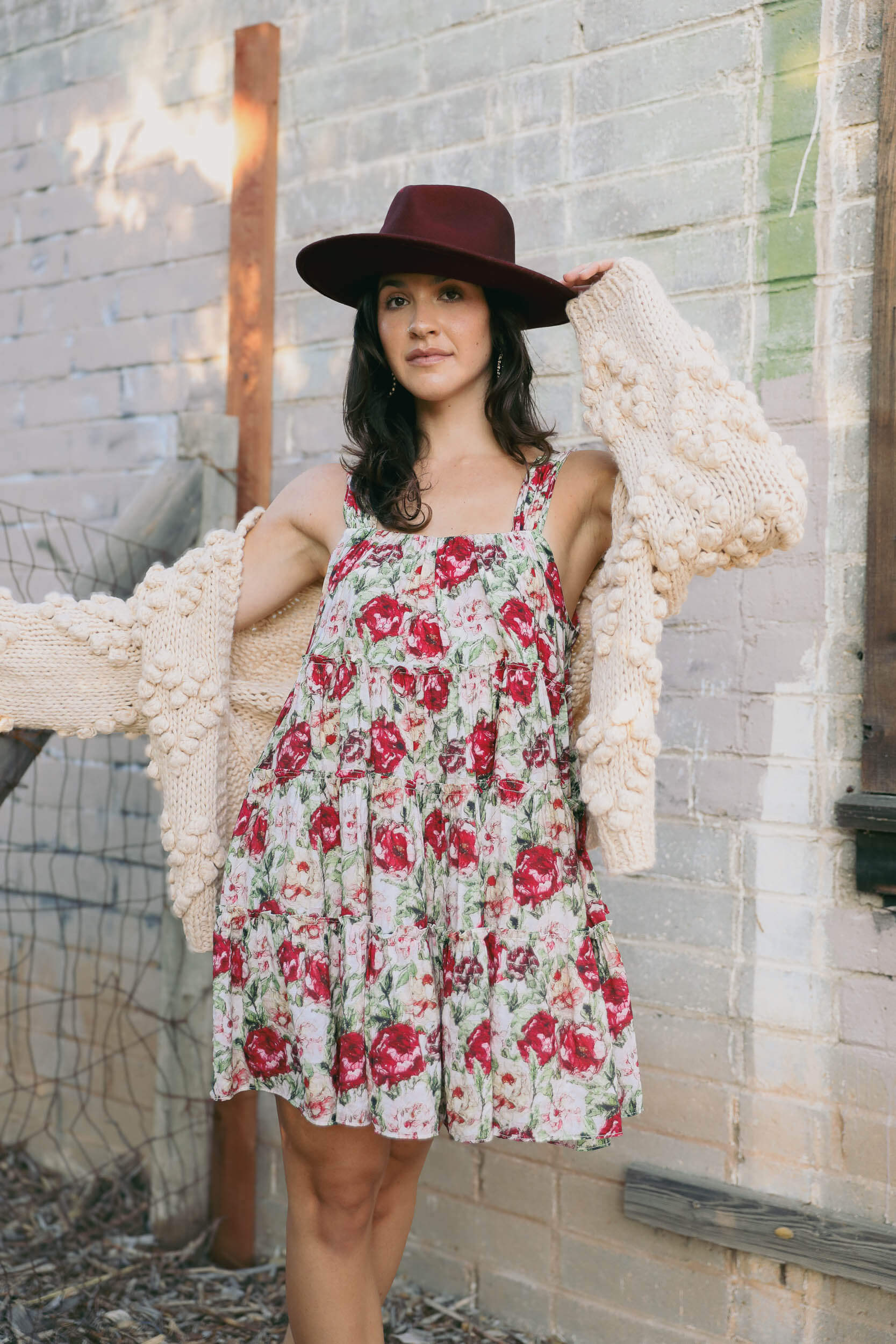 Womens flowy babydoll style dress with red roses displayed throughout