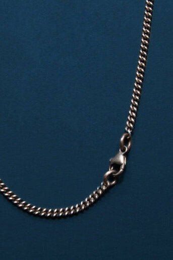 Silver chain necklace on a blue background