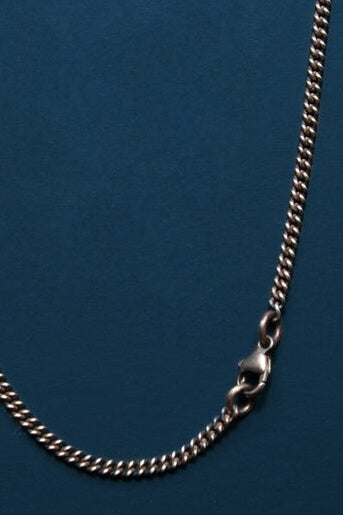 Silver chain necklace on a blue background