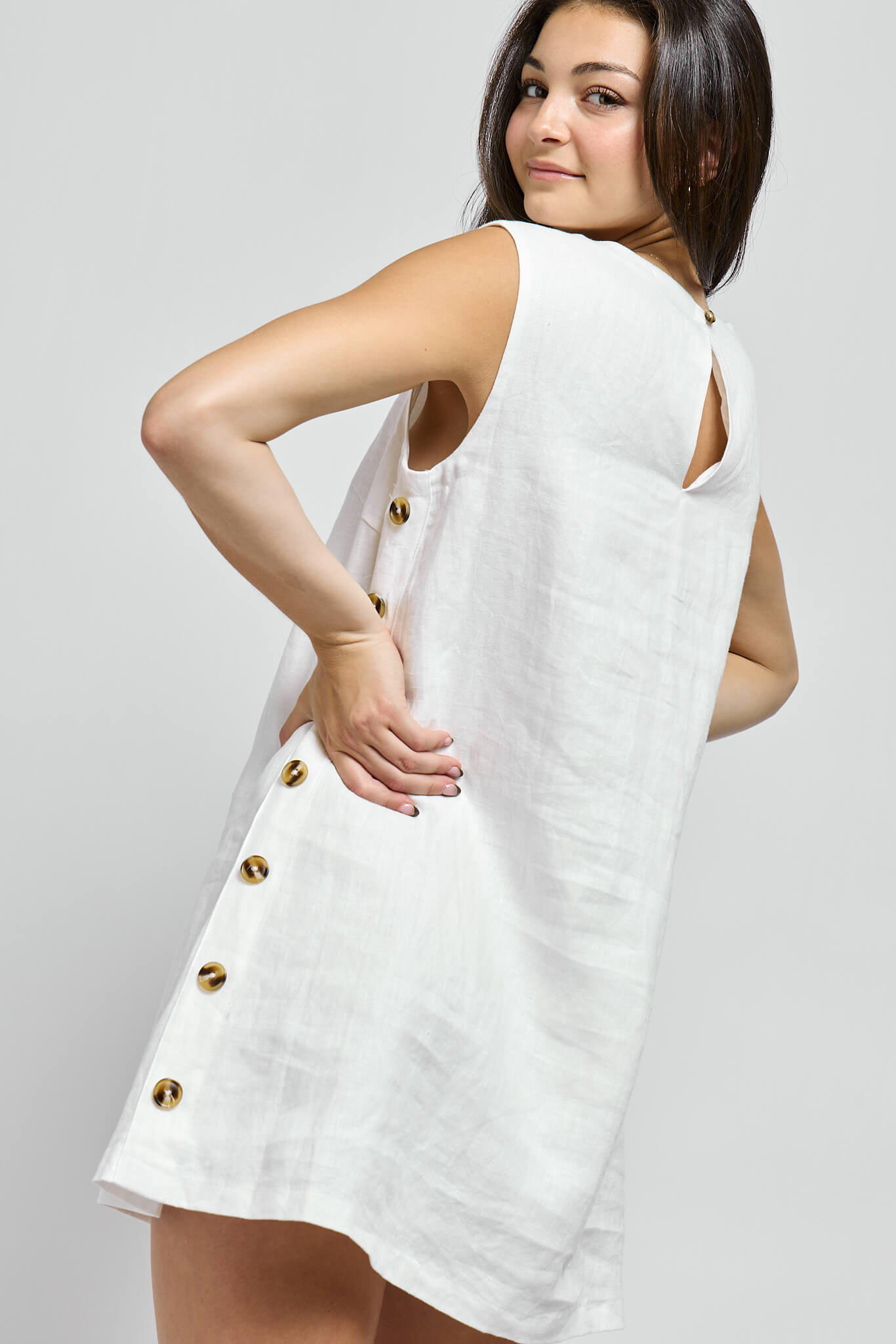 Womens white mini dress with brown side button details, back cutout and button closure