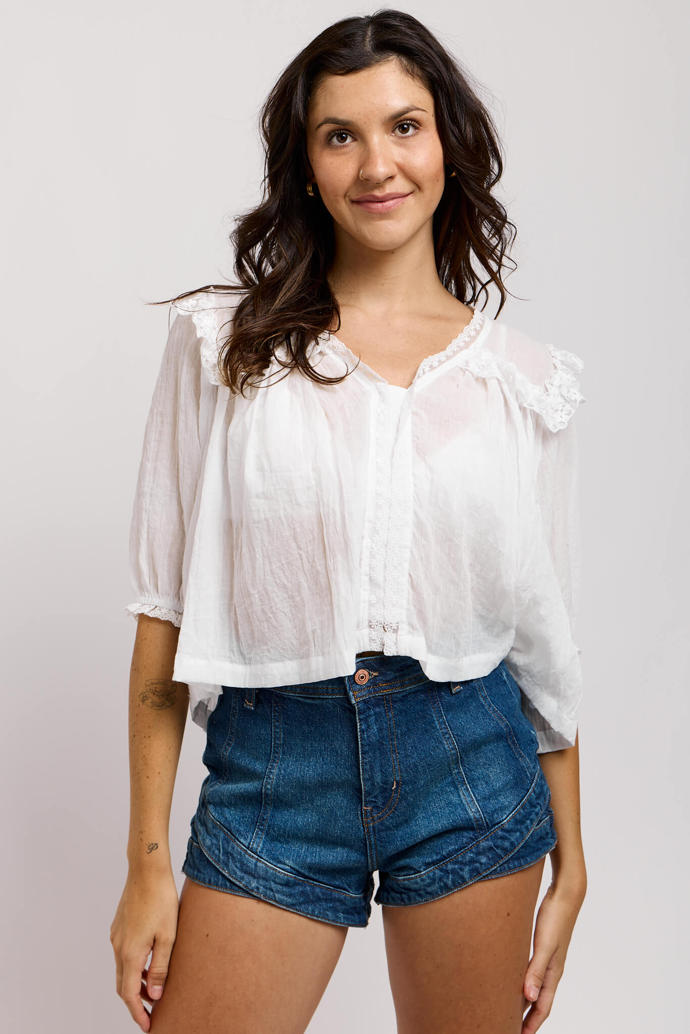 Womens white semi sheer top with dainty ruffle sleeve hem and shoulder ruffle detail
