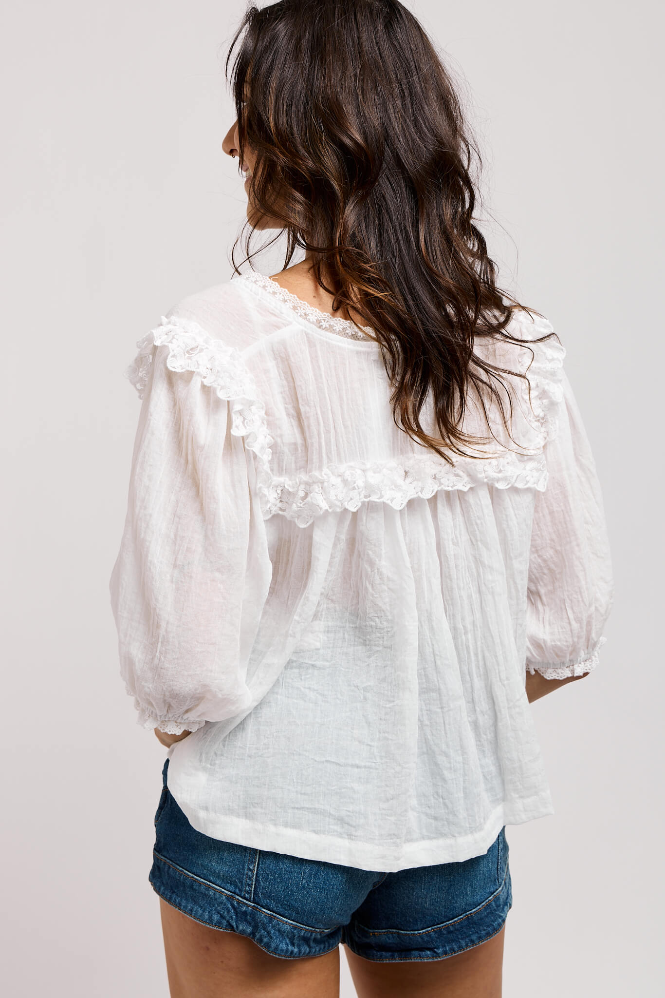 Womens white top with ruffle back detailing and neck lace trim
