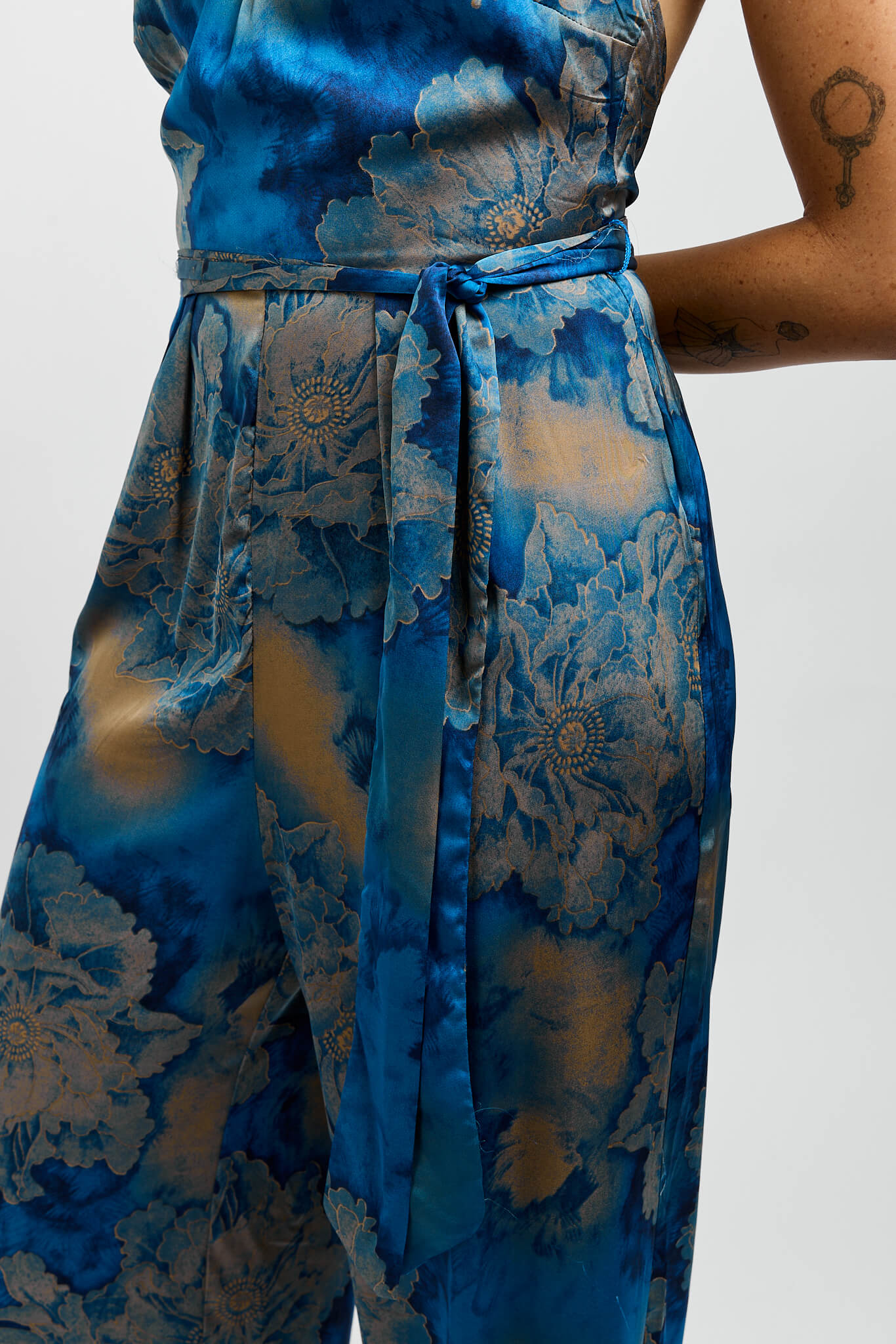 Womens blue silky jumpsuit with gold print and waist belt