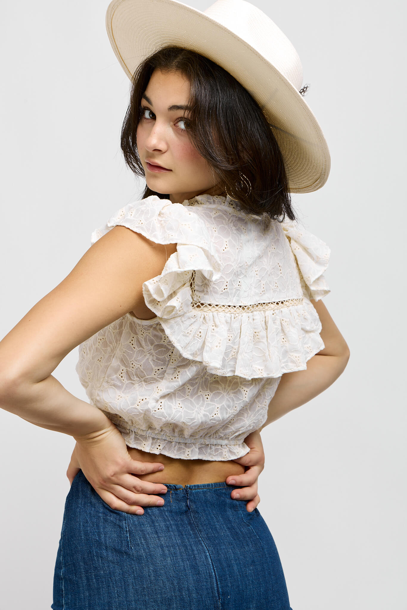 Womens crop top with eyelet and lace details throughout. Ruffle back and sleeve