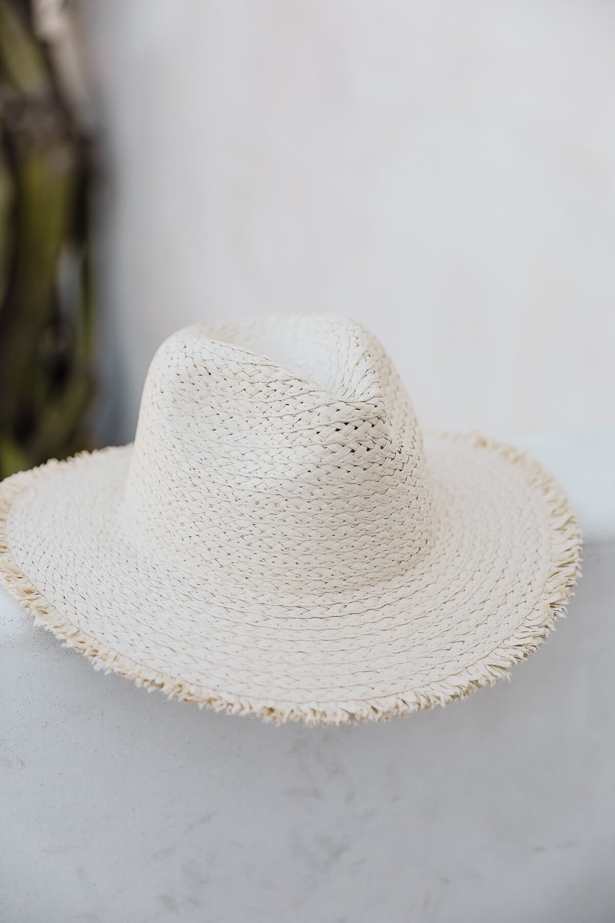 Women's light colored raw hem straw hat