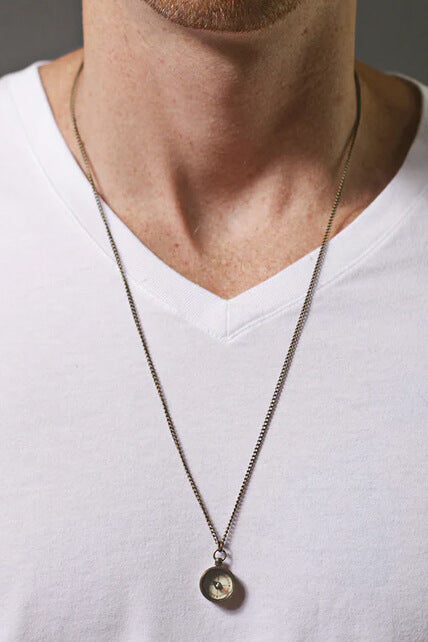 Necklace with a pendant worn by a person in a white shirt