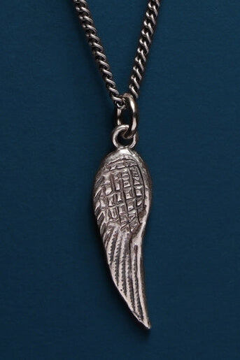 Silver angel wing pendant on a chain against a blue background