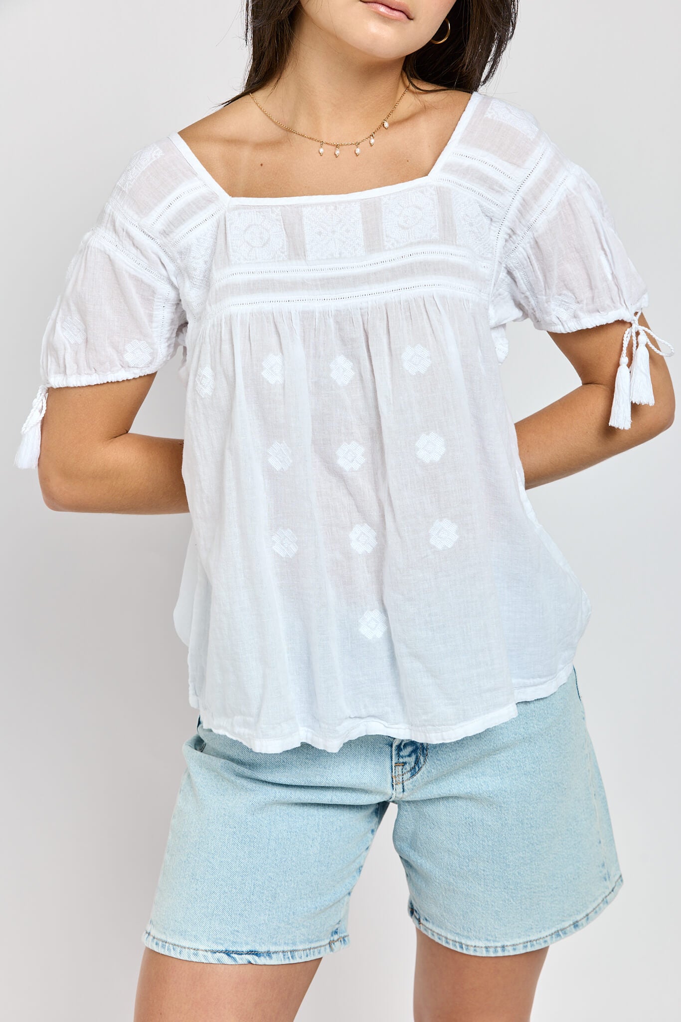 Womens top with crochet details and sleeve tassels