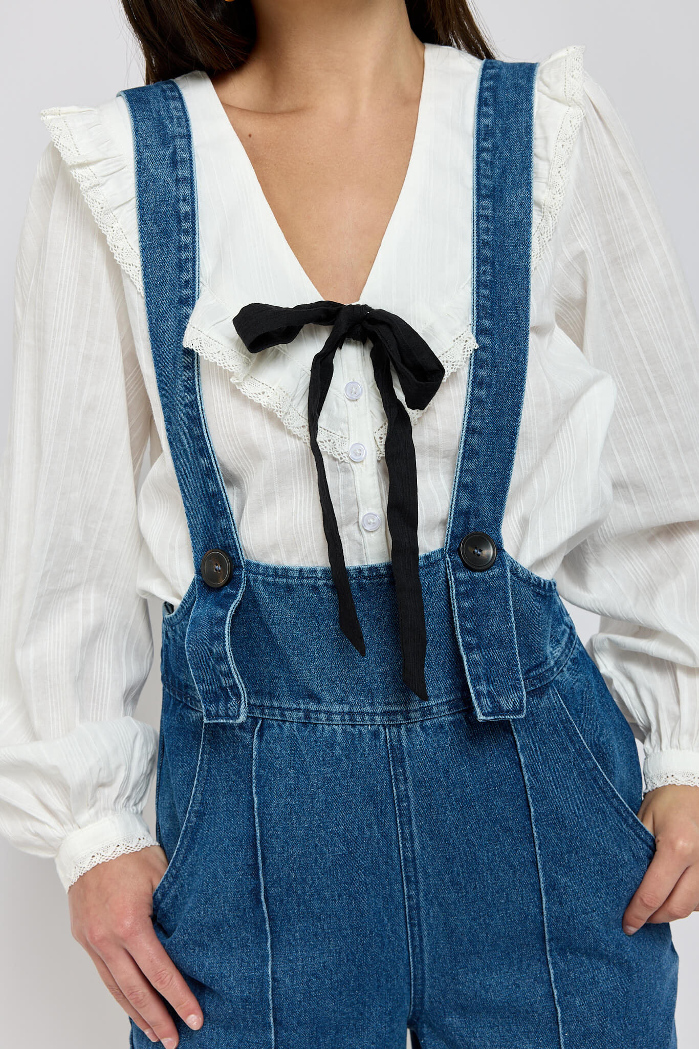 Womens white long sleeve top with black bow detail and lace cuff details