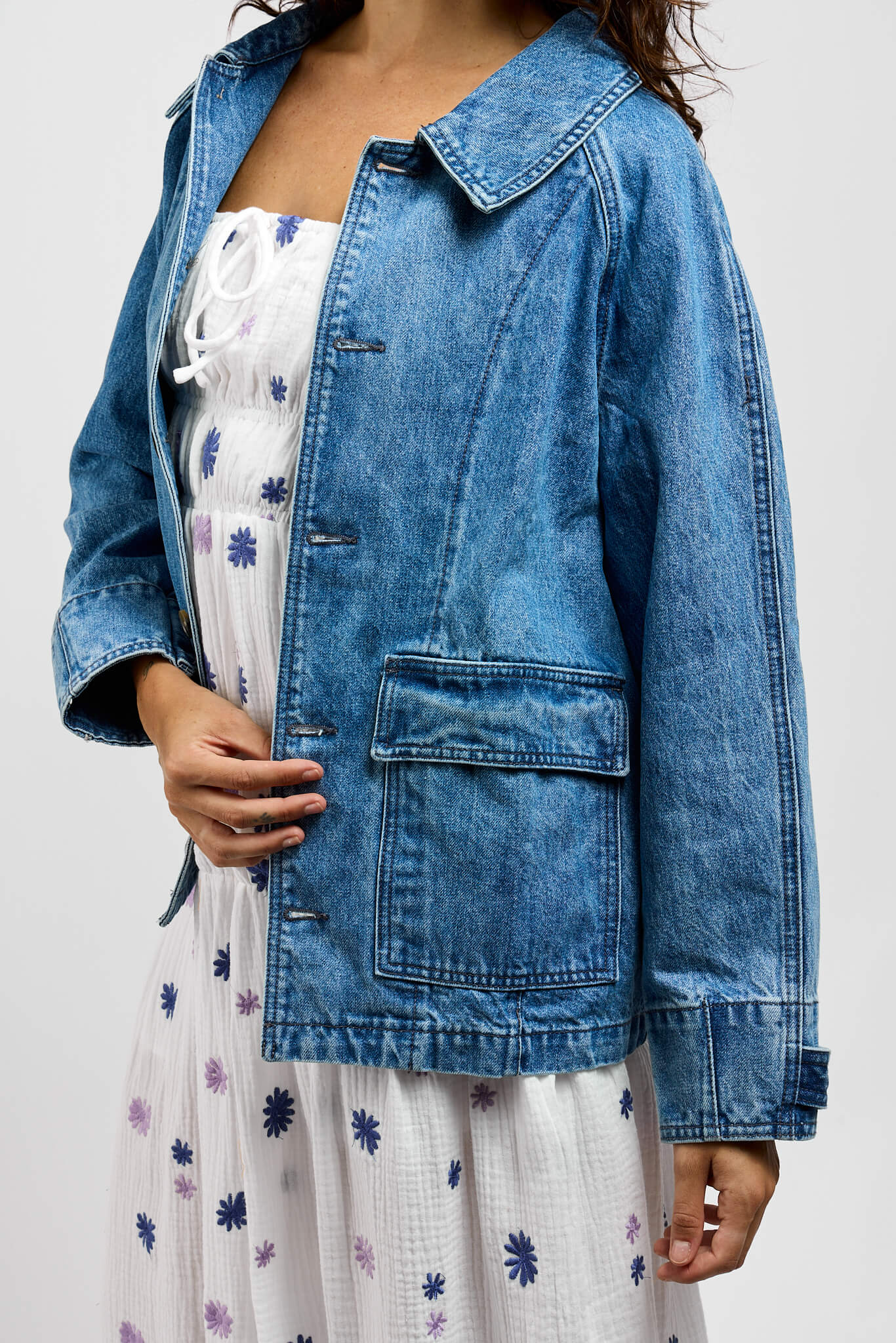 Womens medium wash denim jacket with front flap pockets on lower front