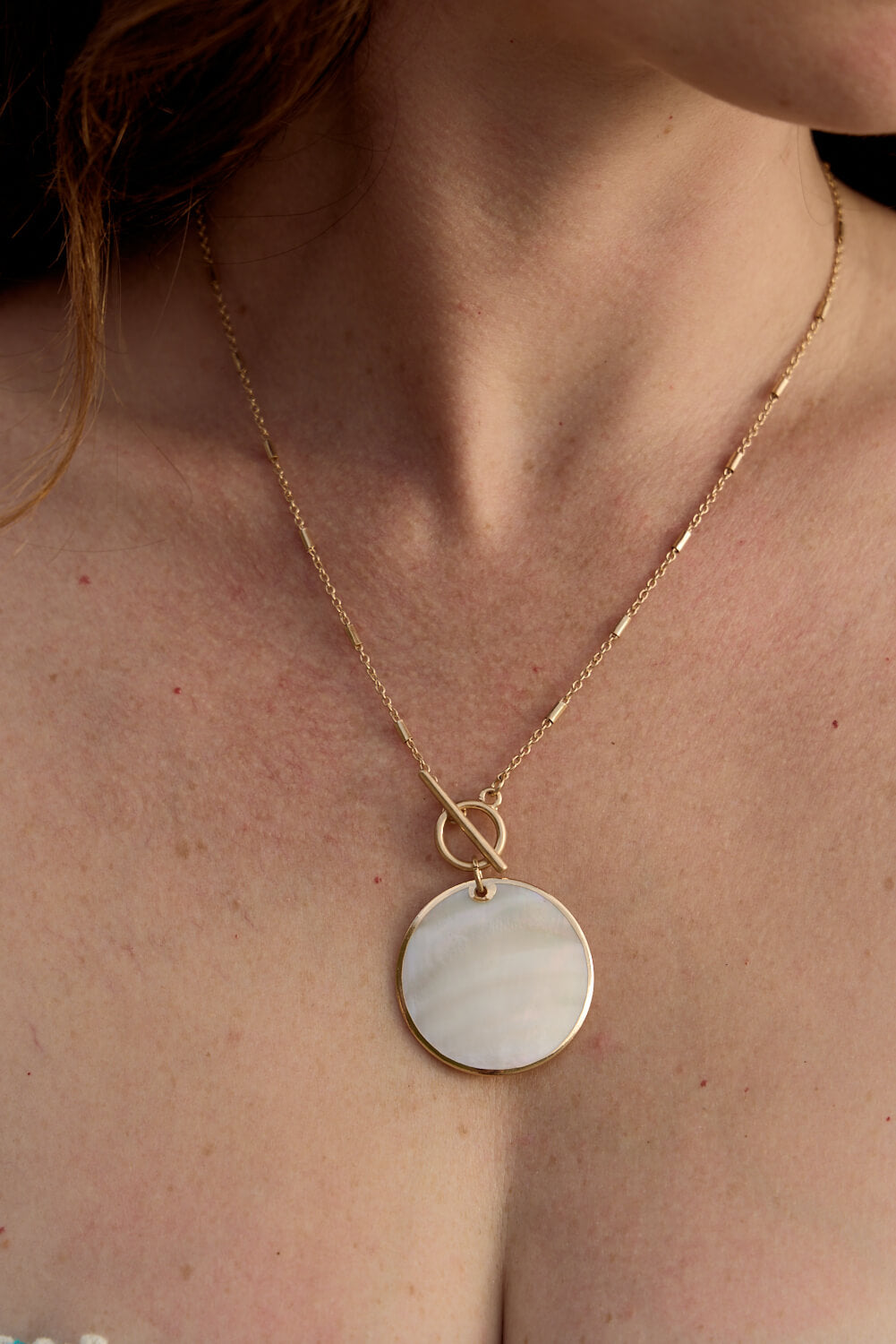 gold chain necklace with mother of pearl round pendant