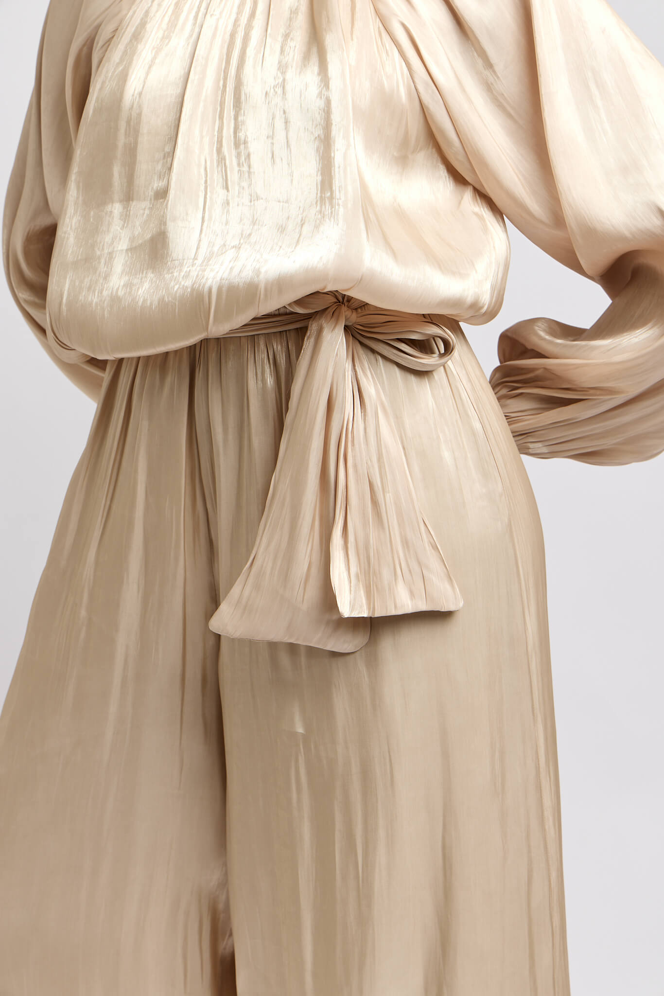 Womens champagne colored jumpsuit that reflects light and an optional flattering waist tie