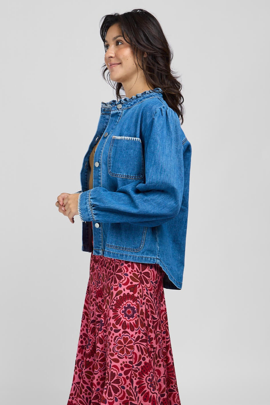 Womens denim jacket with front pockets, cuffed sleeves, and ruffle collart