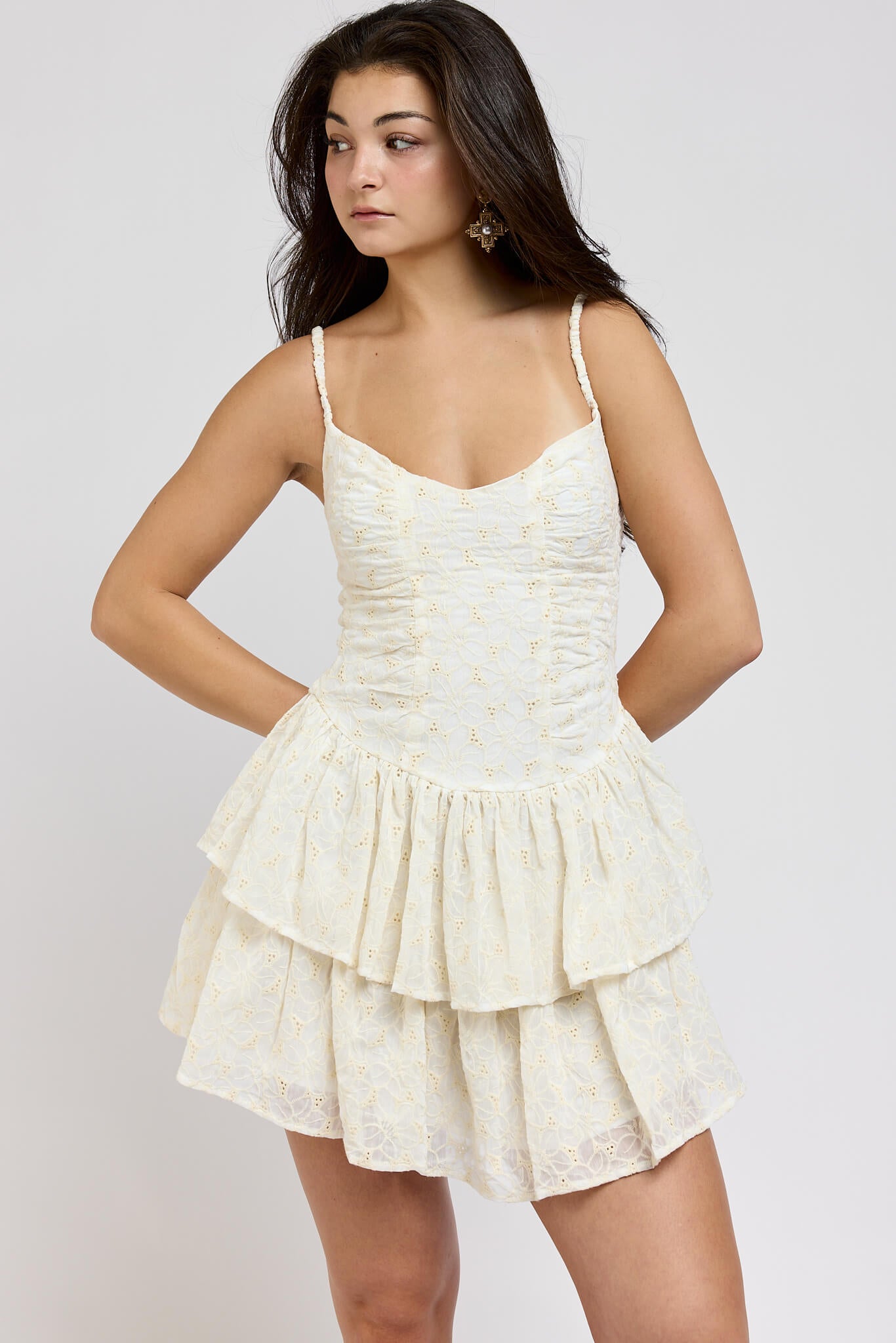 Woman wearing a white lace dress against a plain background