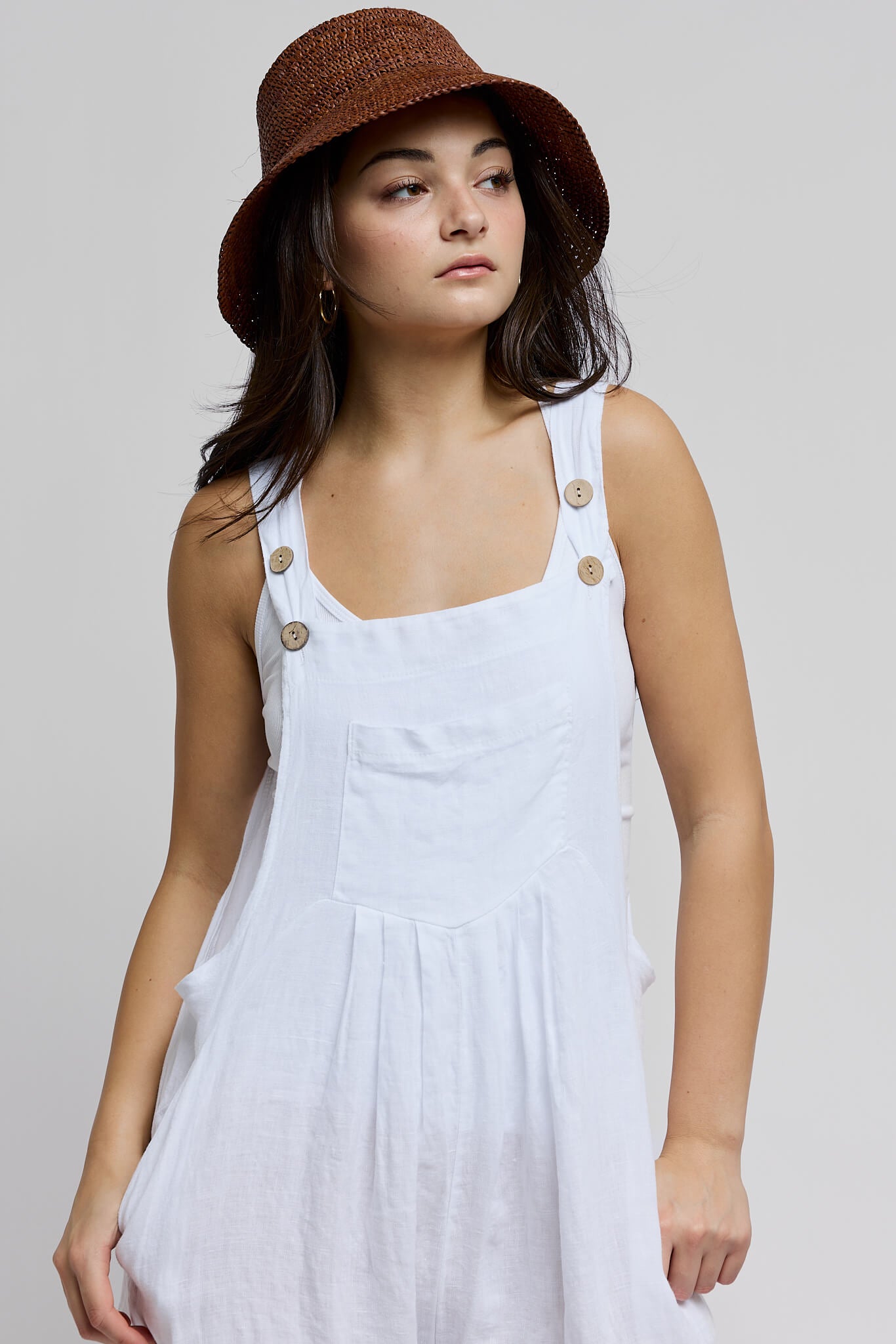Womens white overalls with front chest pocket and adjustable straps with neutral colored buttons